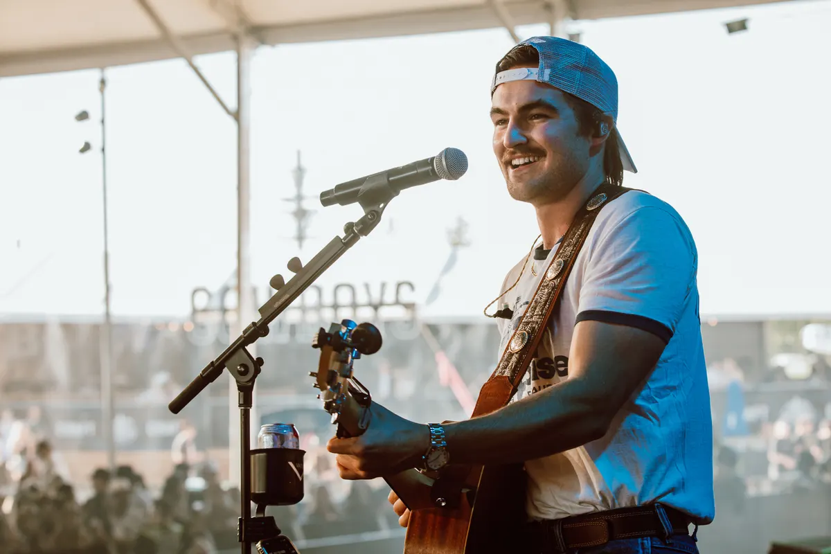 Nik Poli singing and playing guitar on stage at Cowboys, Calgary
